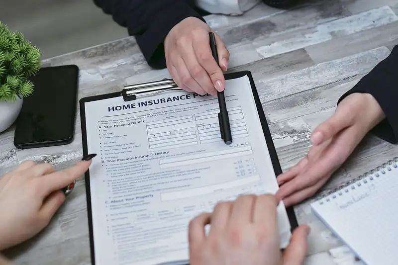 Agent and homeowners reviewing a home insurance form on a clipboard