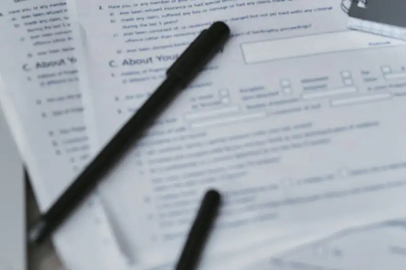 Home insurance policy forms and a notebook on a desk