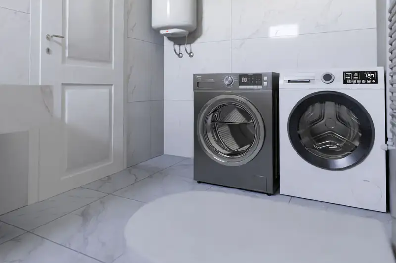 Laundry room with a washer, a dryer and a wall-mounted electric water heater